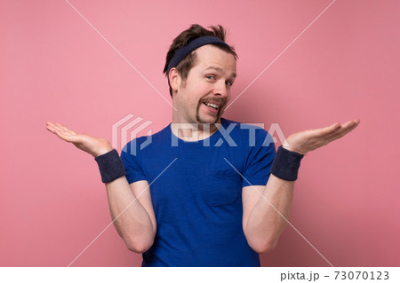 young caucasian fitness man with mustache shrugging shoulders young caucasian fitness man with mustache shrugging shoulders 73070123
