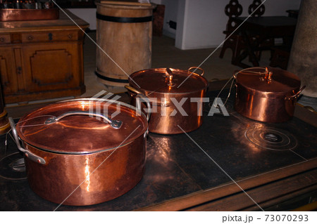 Kitchen of the old castle. Copper pans, baking molds and other kitchen utensils 73070293