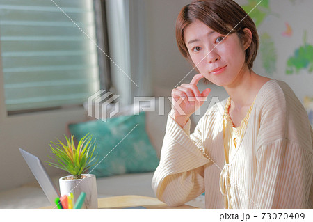 テレワーク_パソコンから目を上げた女性 テレワーク_パソコンから目を上げた女性 73070409
