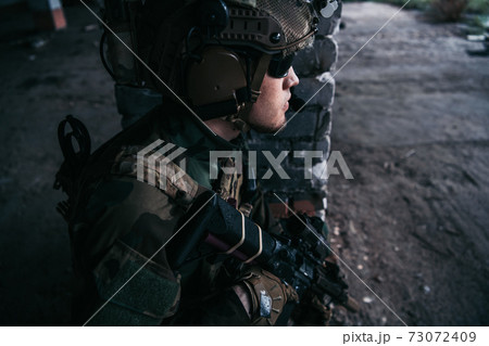 Soldier preparing tactical gear for action battle Soldier preparing tactical gear for action battle 73072409