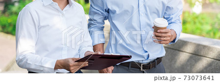 Two Business Colleagues Having Discussion new project business meeting outside office in an urban setting Two Business Colleagues Having Discussion new project business meeting outside office in an urban setting 73073641