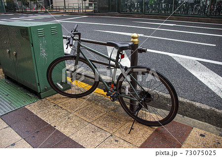 雨に濡れた歩道に止められた自転車 雨に濡れた歩道に止められた自転車 73075025