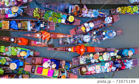 Aerial view famous floating market in Thailand, Damnoen Saduak floating market, Farmer go to sell organic products, fruits, vegetables and Thai cuisine, Tourists visiting by boat, Ratchaburi, Thailand 73075199