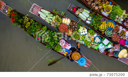 Aerial view famous floating market in Thailand, Damnoen Saduak floating market, Farmer go to sell organic products, fruits, vegetables and Thai cuisine, Tourists visiting by boat, Ratchaburi, Thailand 73075200