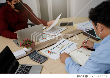 New normal and Social distance conceptual, Employee wearing medical facial mask working in office. New normal and Social distance conceptual, Employee wearing medical facial mask working in office. 73075625