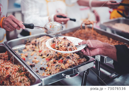 Homeless and needy people receive help, receive food from volunteers Homeless and needy people receive help, receive food from volunteers 73076536