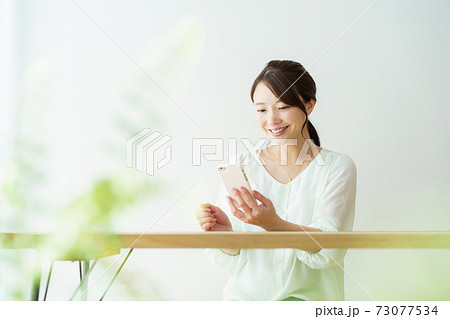 スマホを持つ女性 白背景 スマホを持つ女性 白背景 73077534