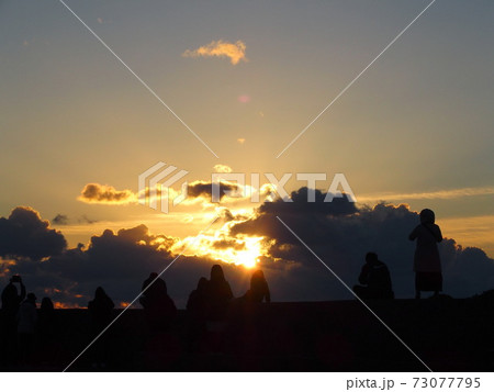 雲間から差し込む日の出 73077795