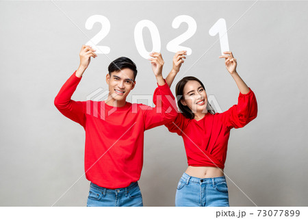 Happy Asian couple smiling and showing number 2021 for new year concept 73077899