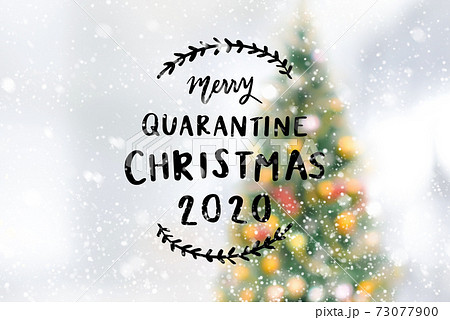 Merry quarantine Christmas 2020 with blurred Christmas tree in snowfall 73077900