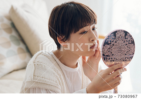 肌荒れを気にする女性・手鏡を見て悩む女性　 73080967