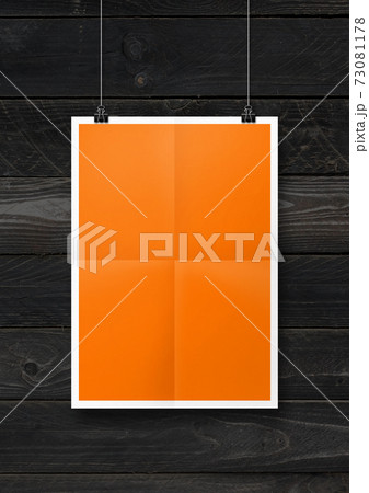 Orange folded poster hanging on a concrete wall with clips Orange folded poster hanging on a concrete wall with clips 73081178
