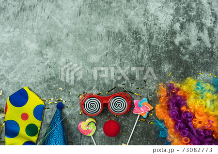 Table top view aerial image of beautiful colorful carnival festival background.Flat lay accessory object the several mask & decor confetti on modern grey cement at home office desk studio.copy space. 73082773