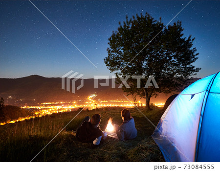 Couple tourists resting at night camping under stars 73084555