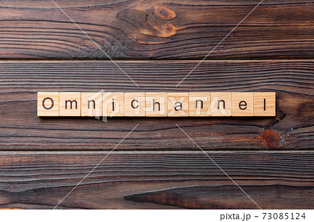 OMNICHANNEL word written on wood block. OMNICHANNEL text on cement table for your desing, concept 73085124