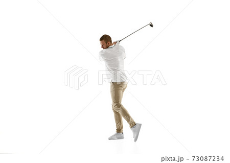 Golf player in a white shirt taking a swing isolated on white studio background 73087234