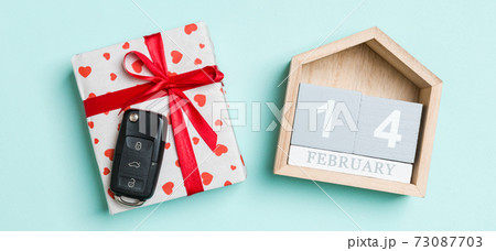 Top view of car key on a gift box with red hearts and festive calendar on colorful background. The fourteenth of february. Present for Valentine's Day concept Top view of car key on a gift box with red hearts and festive calendar on colorful background. The fourteenth of february. Present for Valentine's Day concept 73087703