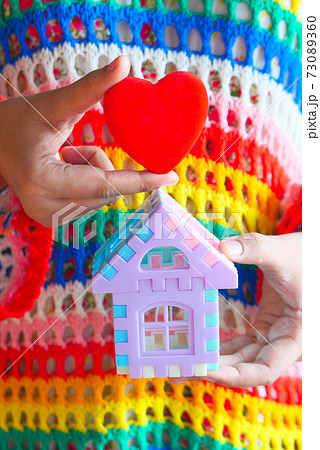 the concept of finance concept , women holding house and red heart in hand  73089360