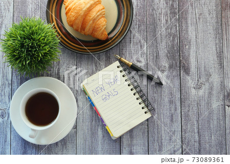 top view of new year goals text on notepad. 73089361