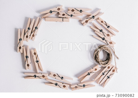 Wooden clothespins with rope on white background. View from above. Place for your text 73090082