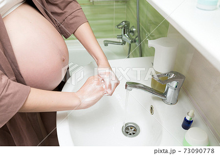 Correct way to wash hands concept. Caucasian pregnant woman washing and cleaning hands and fingers with soap and water. Pregnancy, maternity and bodycare concept 73090778