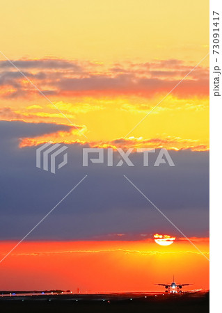 夕景の中離陸する飛行機 73091417