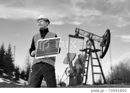 Oil man holding solar panel and giving thumbs up. Oil man holding solar panel and giving thumbs up. 73091602