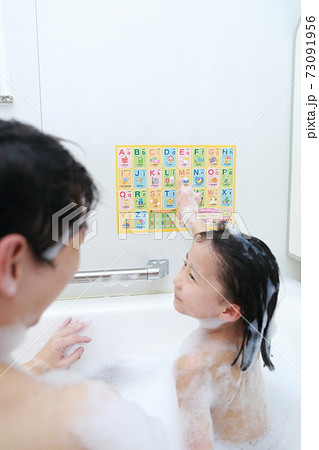お風呂で英語を学習する父親と5歳の娘の写真素材