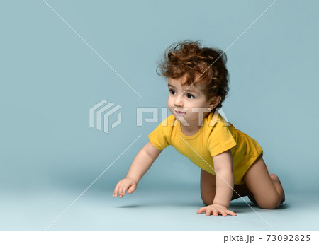 Cute smiling curly baby boy toddler in yellow 73092825