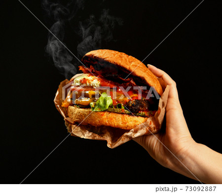 Woman hands hold big cheeseburger barbeque Woman hands hold big cheeseburger barbeque 73092887