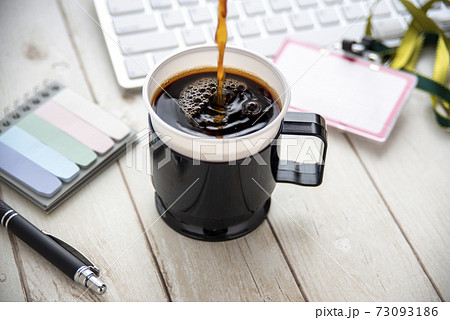 オフィスのテーブルに置かれたコーヒー オフィスのテーブルに置かれたコーヒー 73093186
