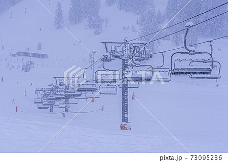 Empty ski slopes and ski lifts in Auron ski resort, France. During the winter holidays of 2020 December and 2021 January lifts are closed for skiing for adults due to the coronavirus pandemic.  73095236