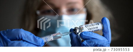 COVID-19 vaccine and syringe in doctor`s hands COVID-19 vaccine and syringe in doctor`s hands 73095553