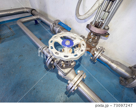 Turning wheel of stopcock valve on stainless pipe branch. Cables to sensor Turning wheel of stopcock valve on stainless pipe branch. Cables to sensor 73097247