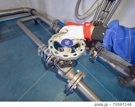 Hand turning manualy with stopcock valve wheel on stainless pip Hand turning manualy with stopcock valve wheel on stainless pip 73097248