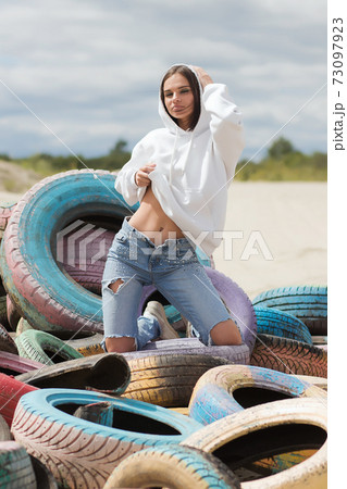 Stylish woman touching belly on beach 73097923