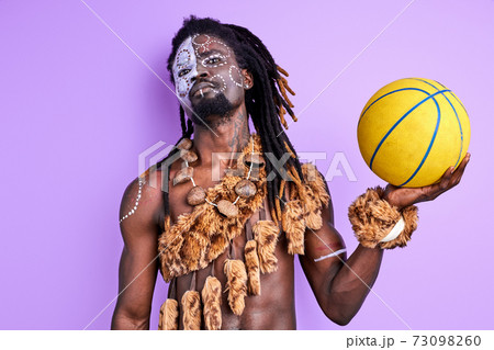 confident afro american pagan male with national make-up holding basketball ball in hands confident afro american pagan male with national make-up holding basketball ball in hands 73098260