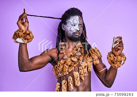 funny shaman tribal male trying to understand how to use modern combs for hair funny shaman tribal male trying to understand how to use modern combs for hair 73098263
