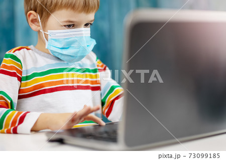 Boy in medical face protection mask indoors on blue background Boy in medical face protection mask indoors on blue background 73099185