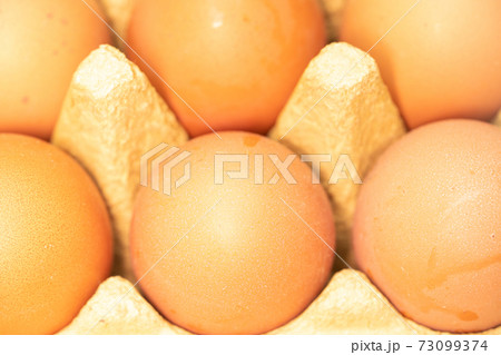 few yellow eggs in a tray close up few yellow eggs in a tray close up 73099374