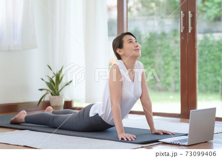 Beautiful asian woman staying fit by exercising at home for healthy trend lifestyle 73099406