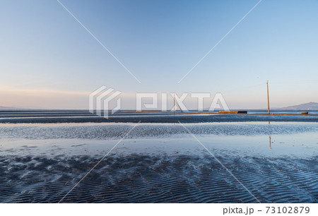 夕暮れの有明海の夕焼けが御輿来海岸の海を染める 73102879