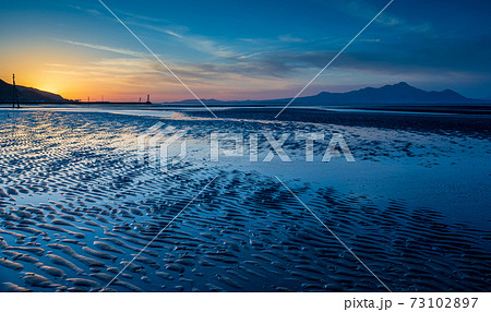 夕暮れの有明海の夕焼けが御輿来海岸の海を染めるの写真素材