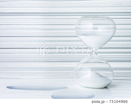 透明感のある背景に置かれた砂時計の写真素材