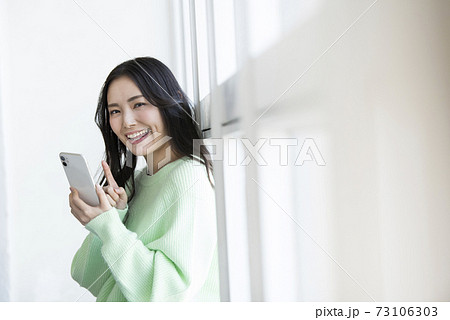 若い女性 スマホ 検索 カメラ目線の写真素材