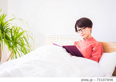 ベッドで読書をする女性 ベッドで読書をする女性 73107846
