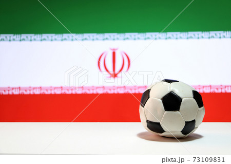 Small football on the white floor and Iranian nation flag background. Small football on the white floor and Iranian nation flag background. 73109831