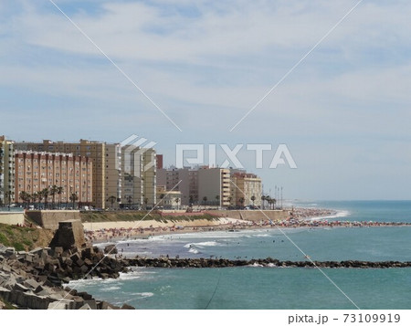 夏の青い海とビーチ、ビーチ沿いに建物が並ぶ風景、スペインカディス・ラ・カレタビーチ 夏の青い海とビーチ、ビーチ沿いに建物が並ぶ風景、スペインカディス・ラ・カレタビーチ 73109919