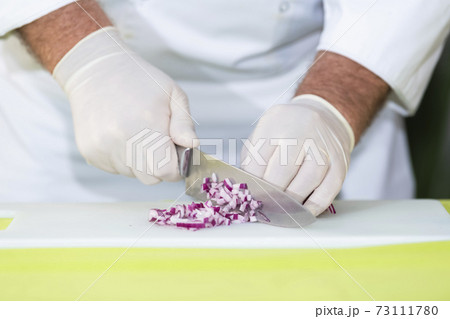 Chef cutting a red onion into dice Chef cutting a red onion into dice 73111780