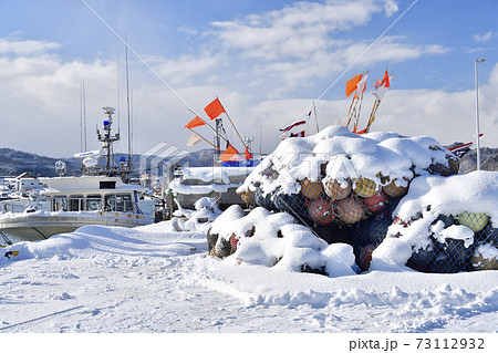 冬の北海道八雲町落部漁港で雪をかぶった浮き球の風景を撮影 73112932